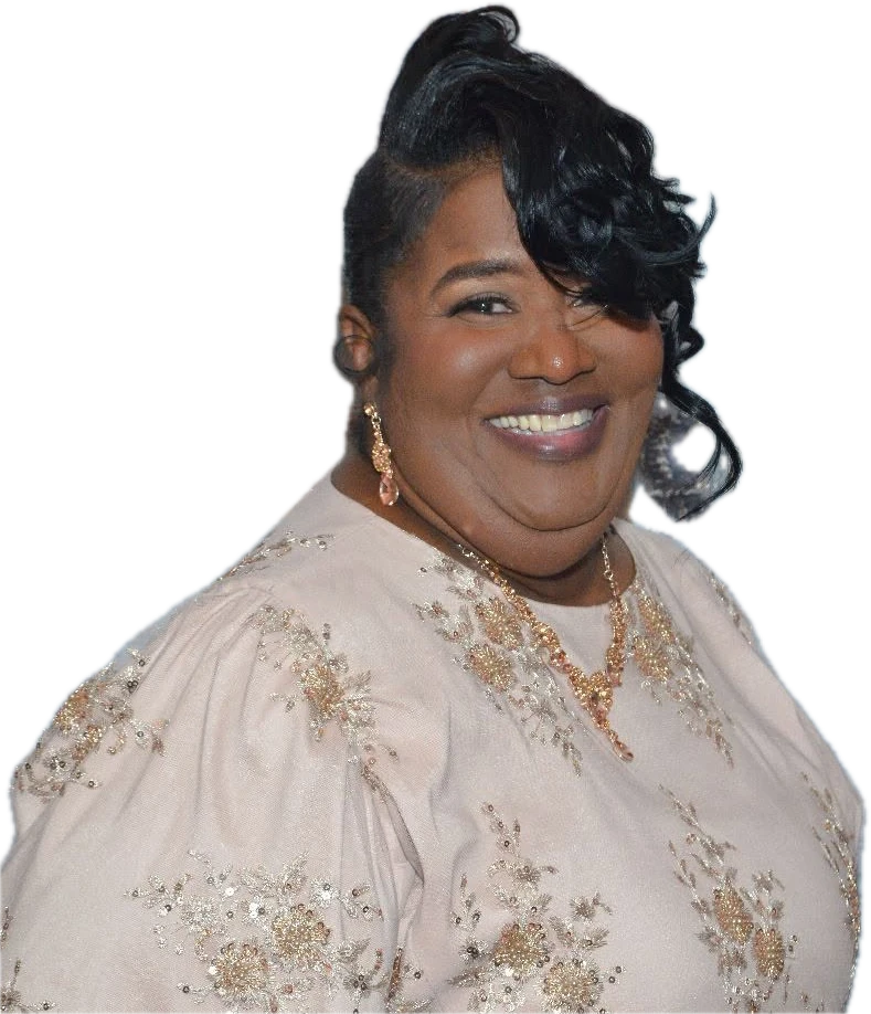 Overseer Turlyn Betterson, smiling, in a cream dress with gold embroidery